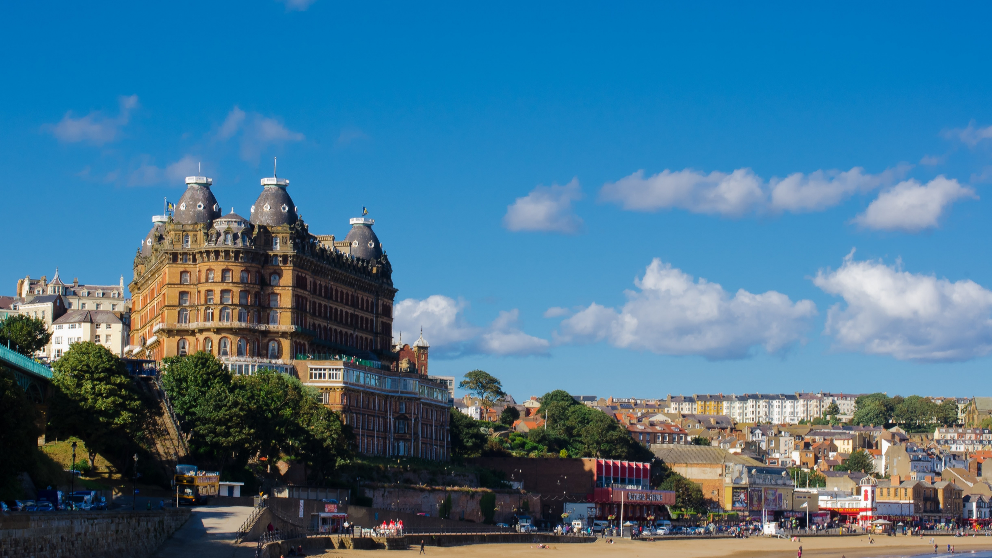 Personnes Marchant Dans la Rue Près D'un Bâtiment en Béton Brun Sous un Ciel Bleu Pendant la Journée. Wallpaper in 3840x2160 Resolution