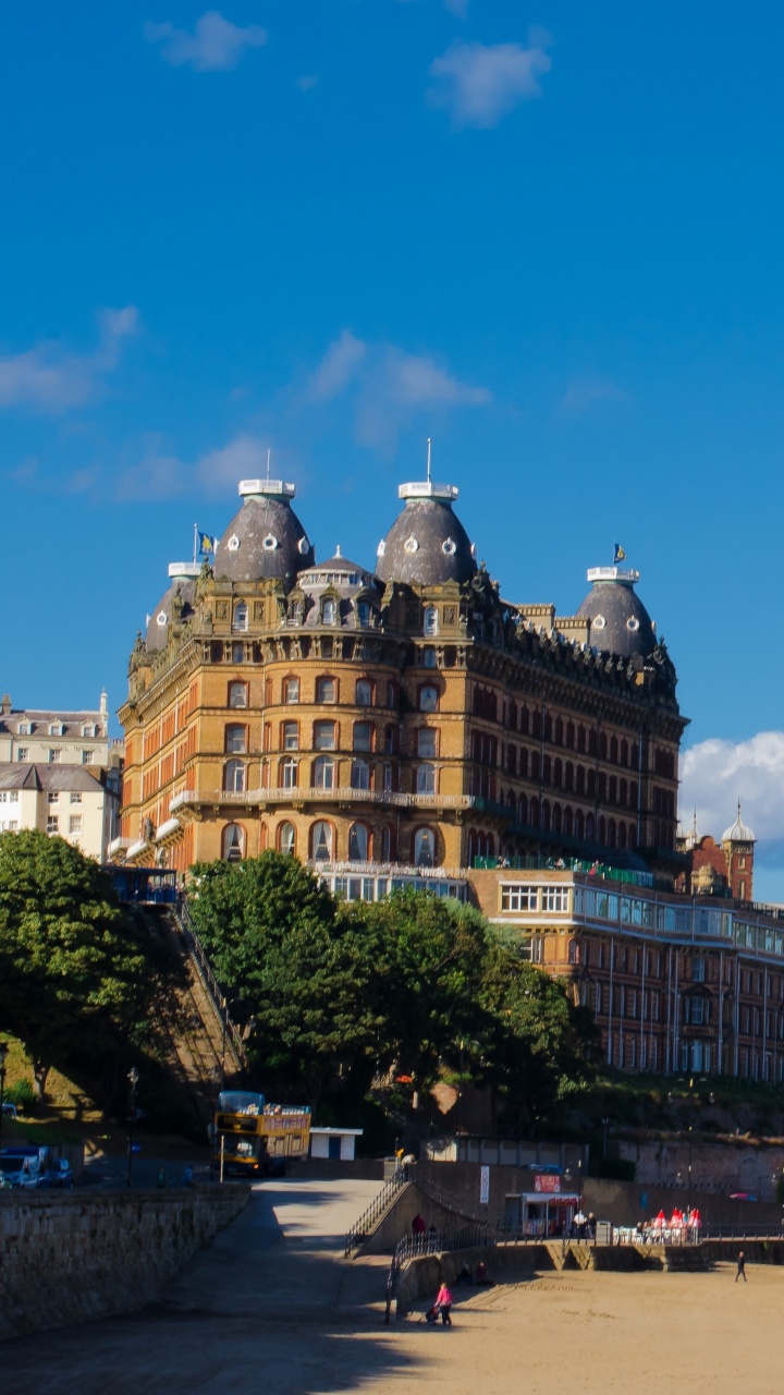 Personnes Marchant Dans la Rue Près D'un Bâtiment en Béton Brun Sous un Ciel Bleu Pendant la Journée. Wallpaper in 720x1280 Resolution