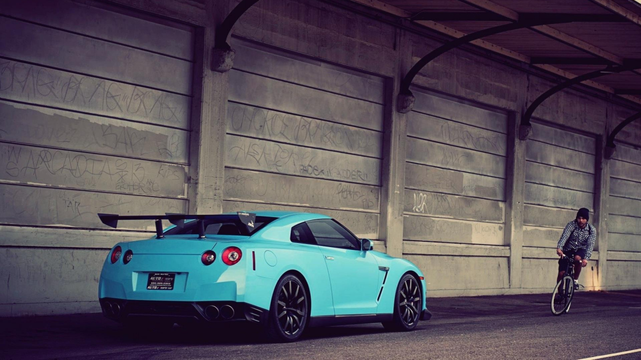 Blue Porsche 911 Parked Beside Brick Wall. Wallpaper in 1280x720 Resolution