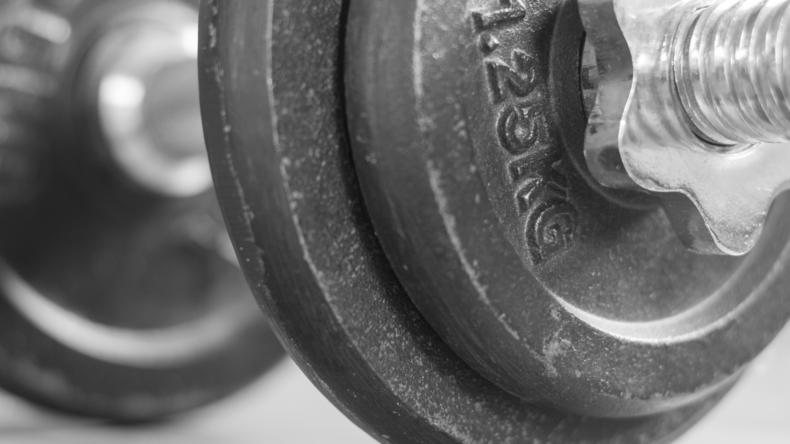 Schwarze Hantel Auf Weißem Textil. Wallpaper in 2560x1440 Resolution