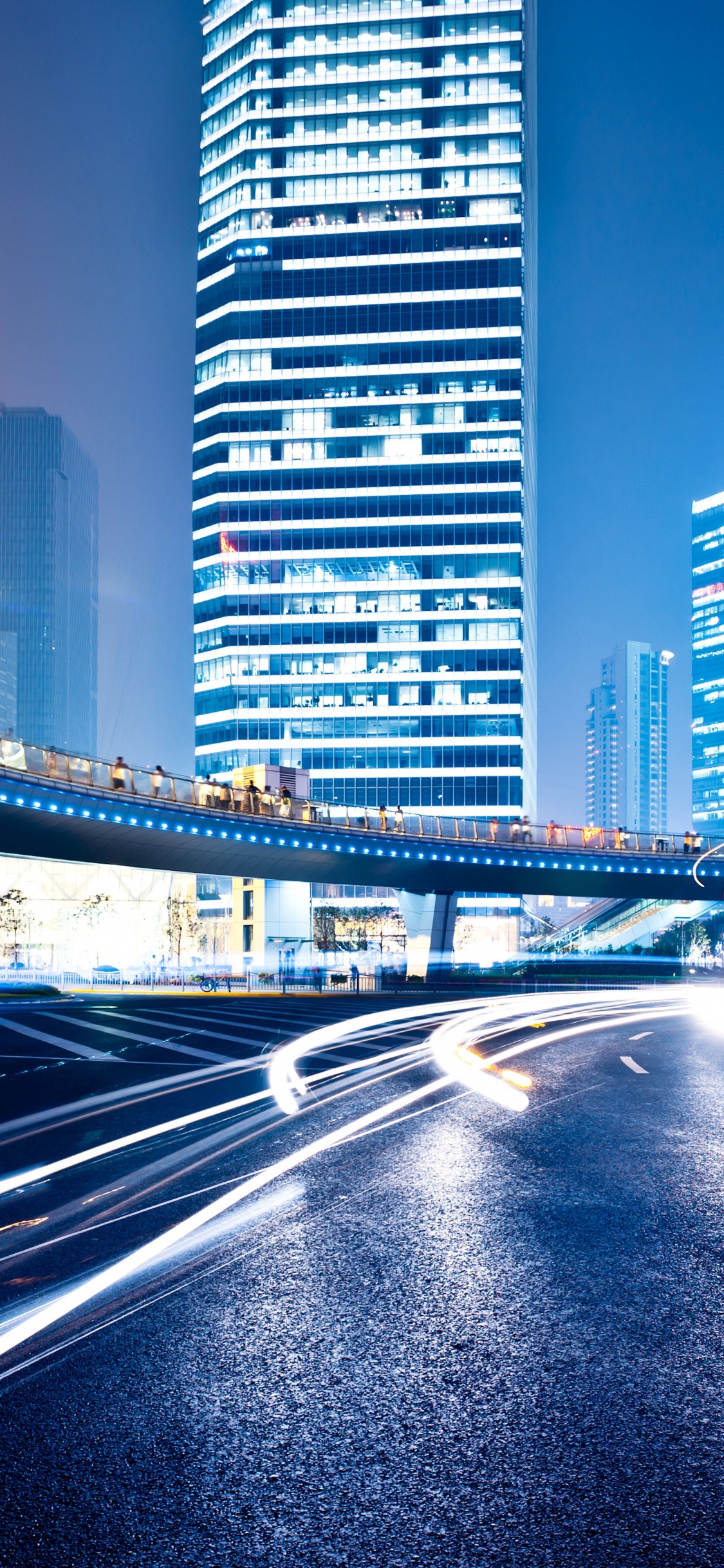 Autos Auf Der Straße in Der Nähe Von Hochhäusern Tagsüber. Wallpaper in 1125x2436 Resolution