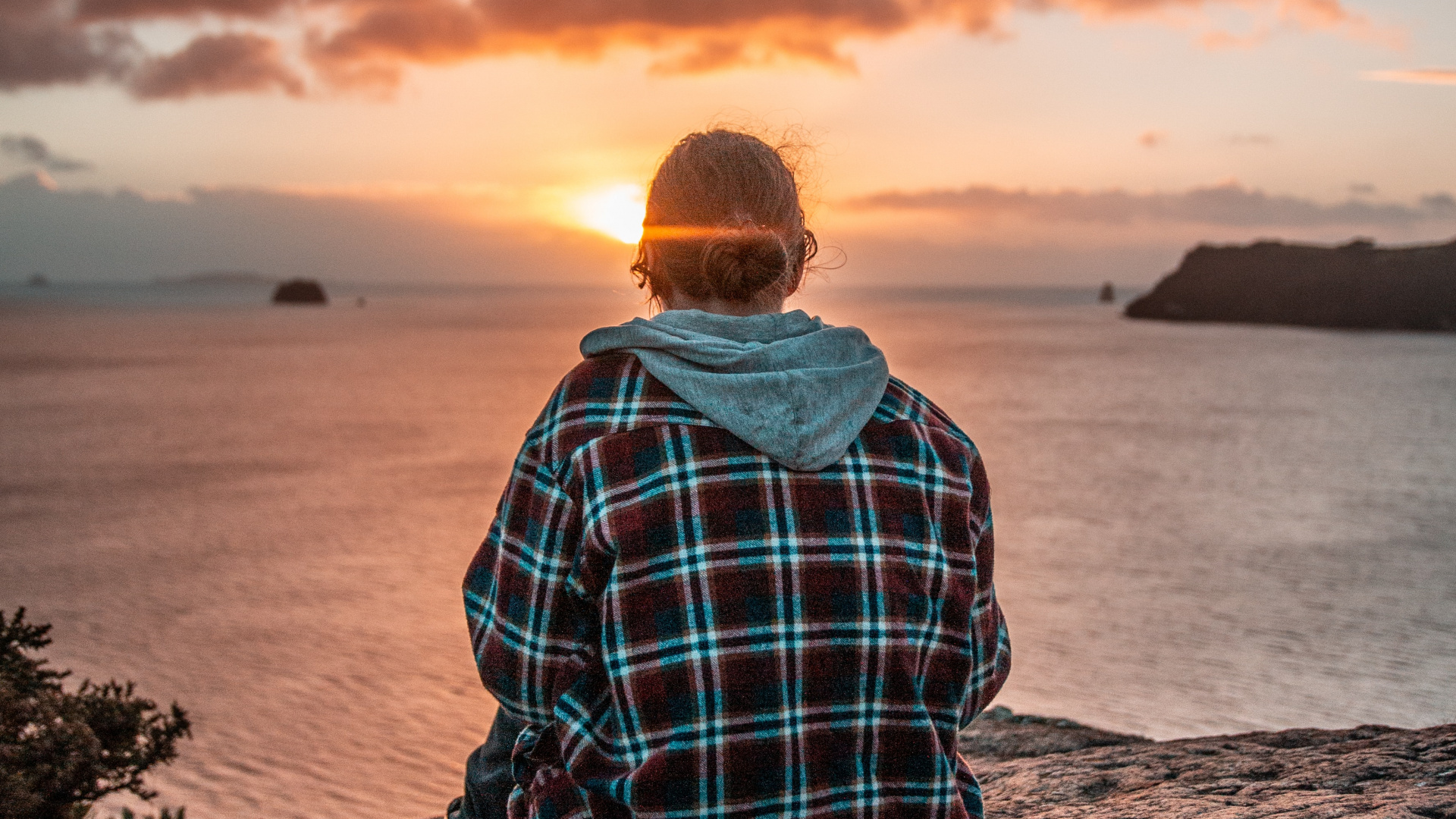Man in Blue and White Plaid Dress Shirt Sitting on Rock Near Body of Water During. Wallpaper in 1920x1080 Resolution