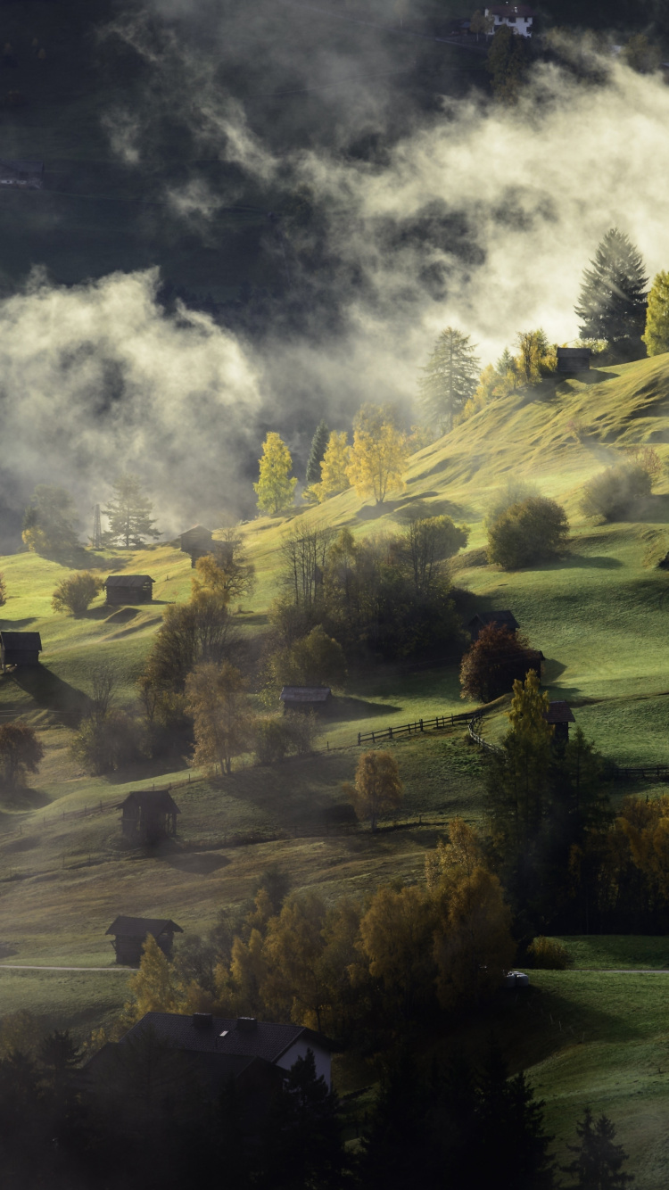 Grüne Wiese in Der Nähe Des Sees Unter Bewölktem Himmel Tagsüber. Wallpaper in 750x1334 Resolution