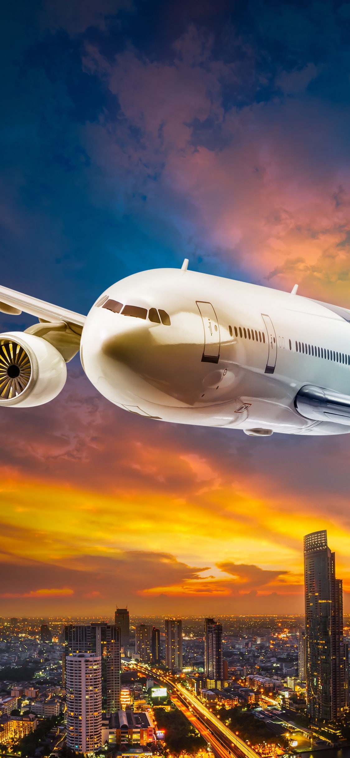 Weißes Passagierflugzeug, Das Tagsüber Über Stadtgebäude Fliegt. Wallpaper in 1125x2436 Resolution