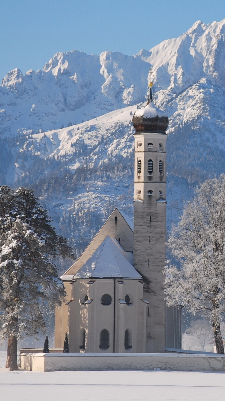 Bâtiment en Béton Blanc et Marron Près Des Arbres et de la Montagne Pendant la Journée. Wallpaper in 750x1334 Resolution