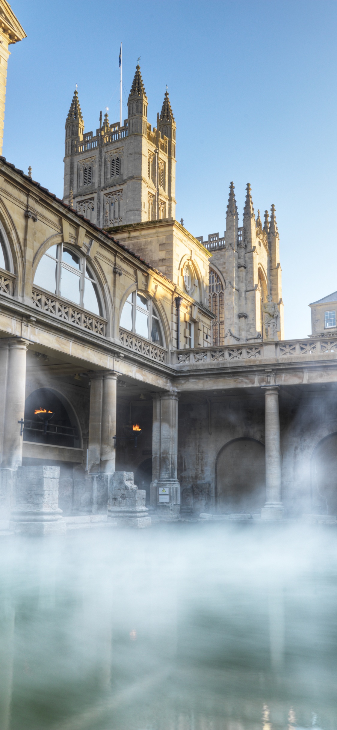Beige Concrete Building Near Water Fountain. Wallpaper in 1125x2436 Resolution