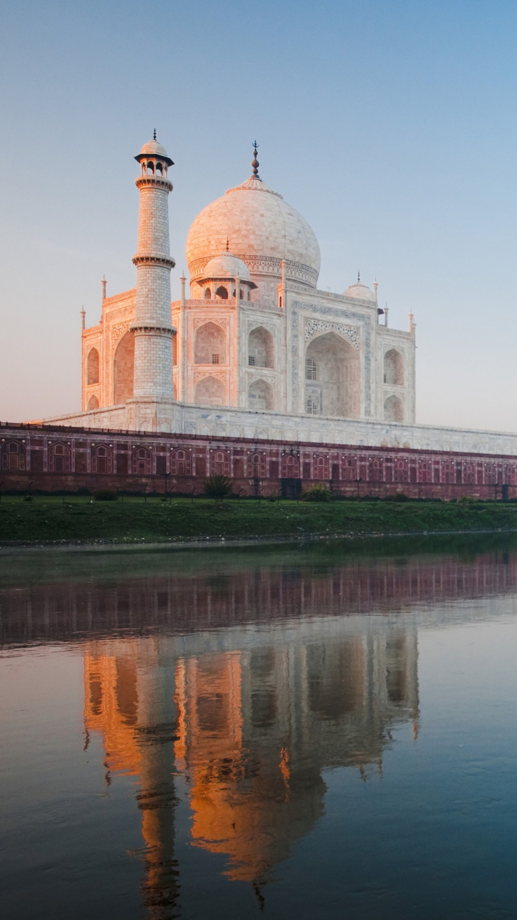 White and Brown Concrete Building Near Body of Water During Daytime. Wallpaper in 750x1334 Resolution