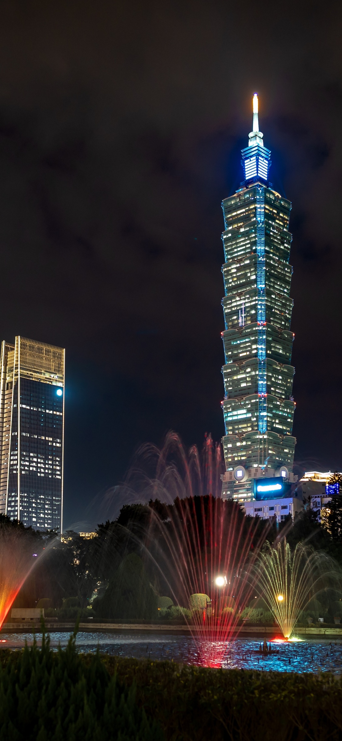 Edificio Alto Iluminado Durante la Noche.. Wallpaper in 1125x2436 Resolution