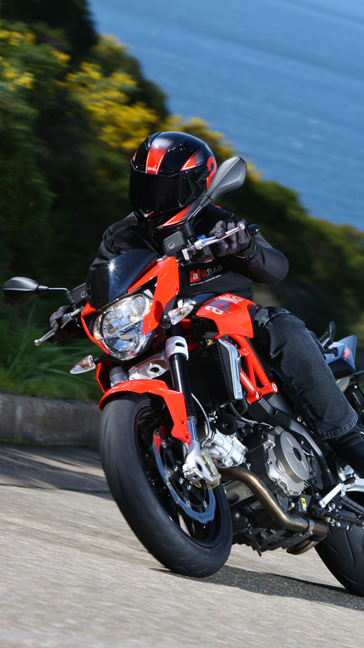 Homme en Costume de Moto Orange et Noir Équitation Sur Moto Sur Route Pendant la Journée. Wallpaper in 750x1334 Resolution