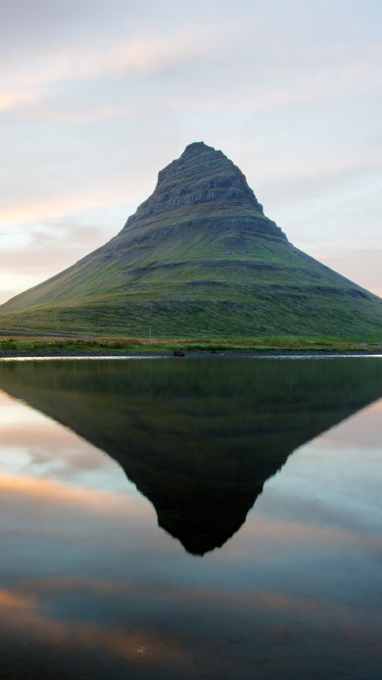 Green Mountain Beside Body of Water Under Cloudy Sky During Daytime. Wallpaper in 750x1334 Resolution
