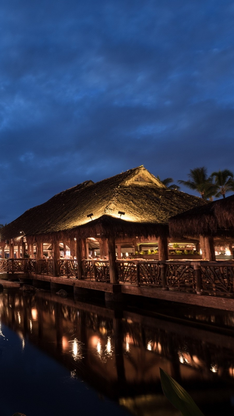 Brown Wooden House Near Body of Water During Night Time. Wallpaper in 750x1334 Resolution