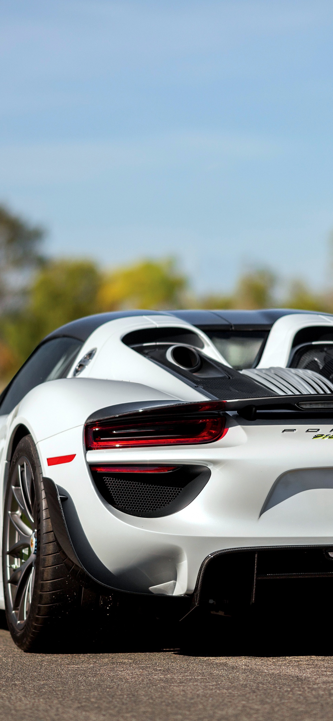 Premium AI Image | A porsche 918 is parked on a road in the rain.