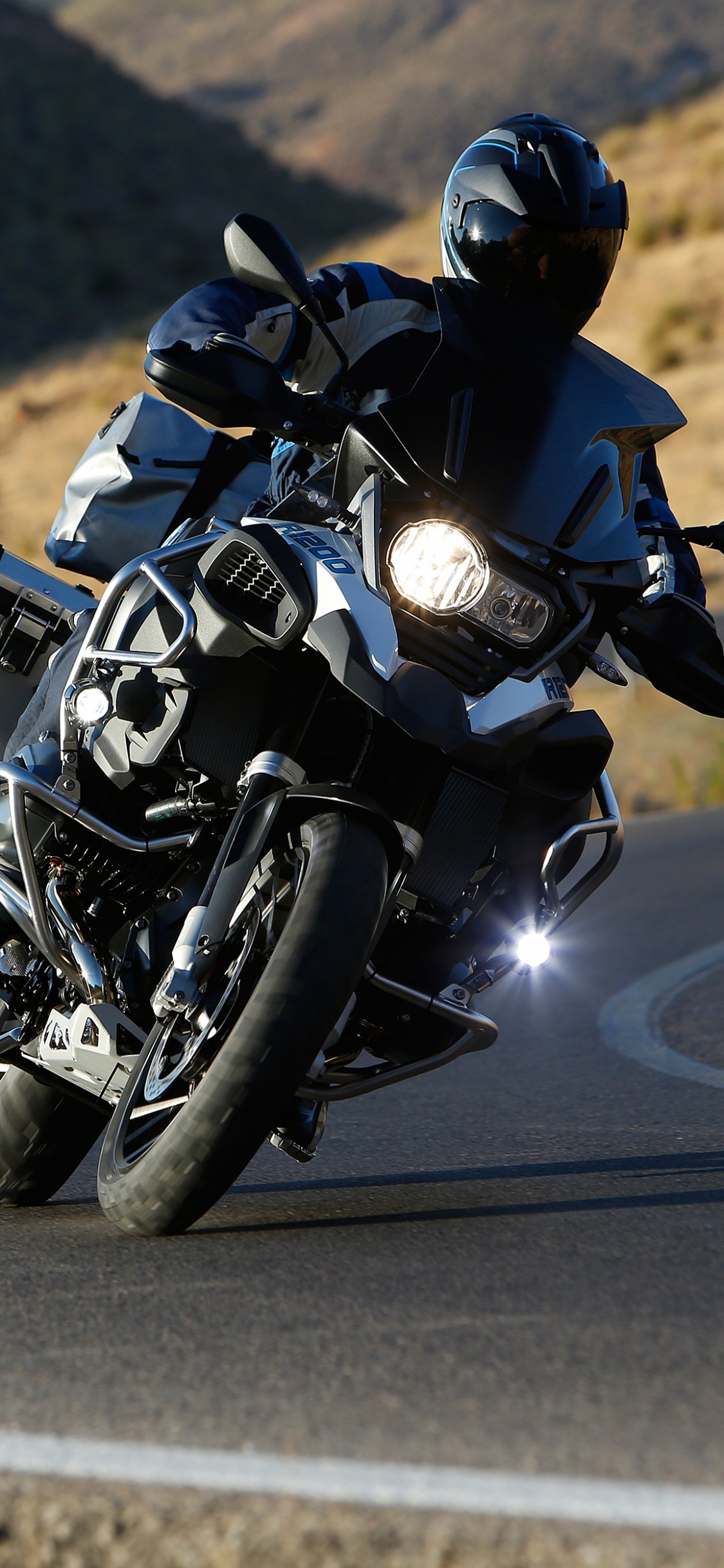 Man in Black Motorcycle Suit Riding Motorcycle on Road During Daytime. Wallpaper in 1125x2436 Resolution