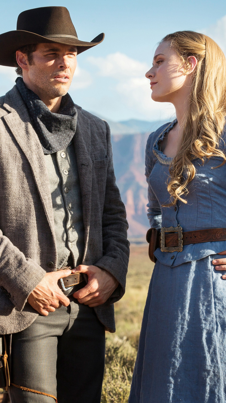 Woman in Blue Dress Standing Beside Man in Brown Jacket. Wallpaper in 750x1334 Resolution