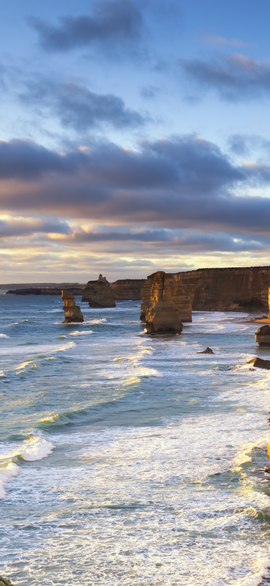 Brown Rock Formation on Sea Shore Under Cloudy Sky During Daytime. Wallpaper in 1125x2436 Resolution