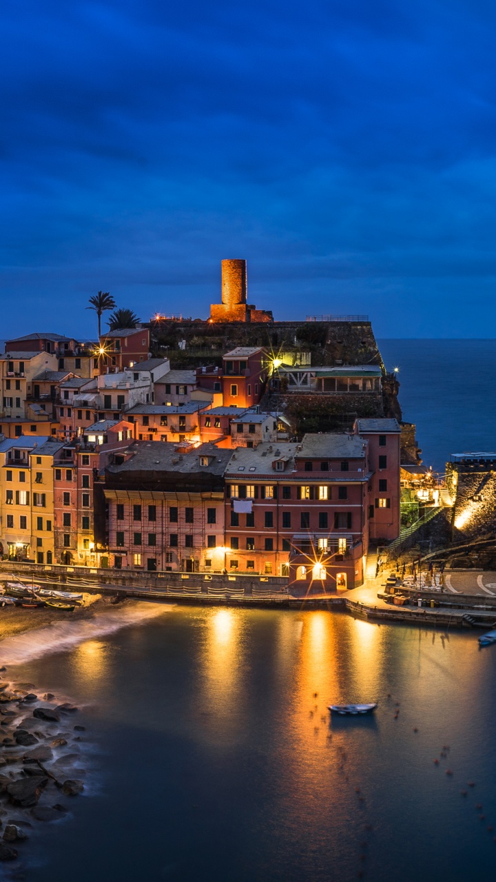 Weißes Und Braunes Betongebäude in Der Nähe Eines Gewässers Während Der Nacht. Wallpaper in 720x1280 Resolution