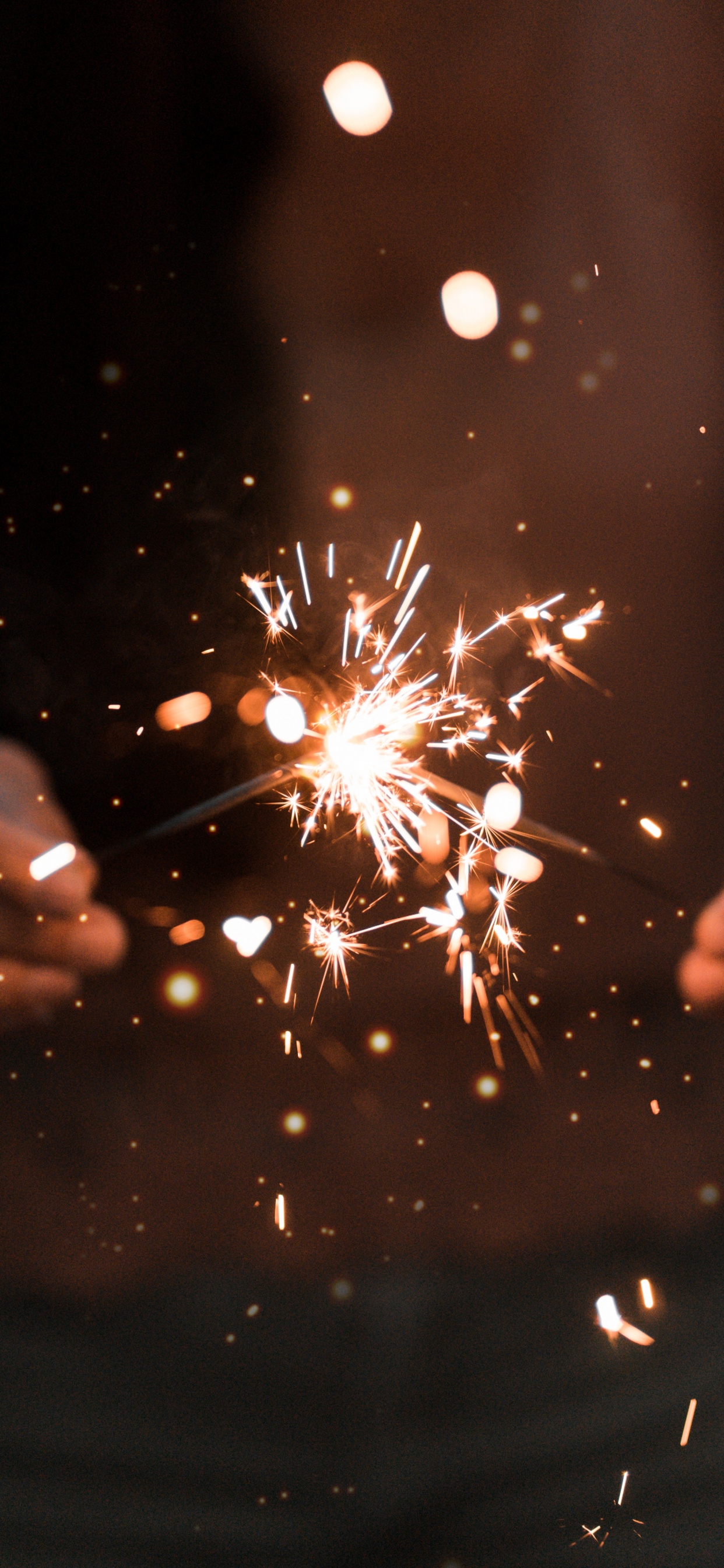 Person Holding Sparkler During Night Time. Wallpaper in 1242x2688 Resolution