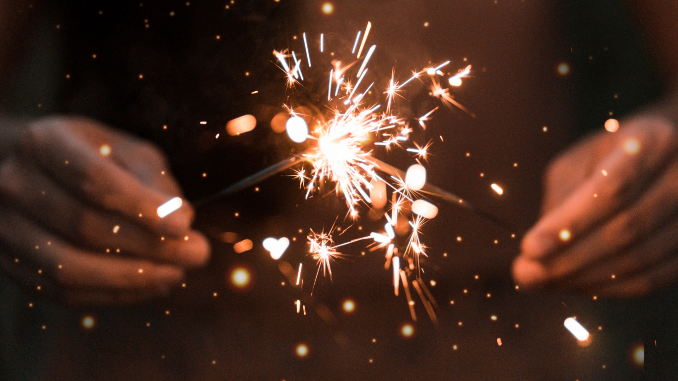Person Holding Sparkler During Night Time. Wallpaper in 1366x768 Resolution