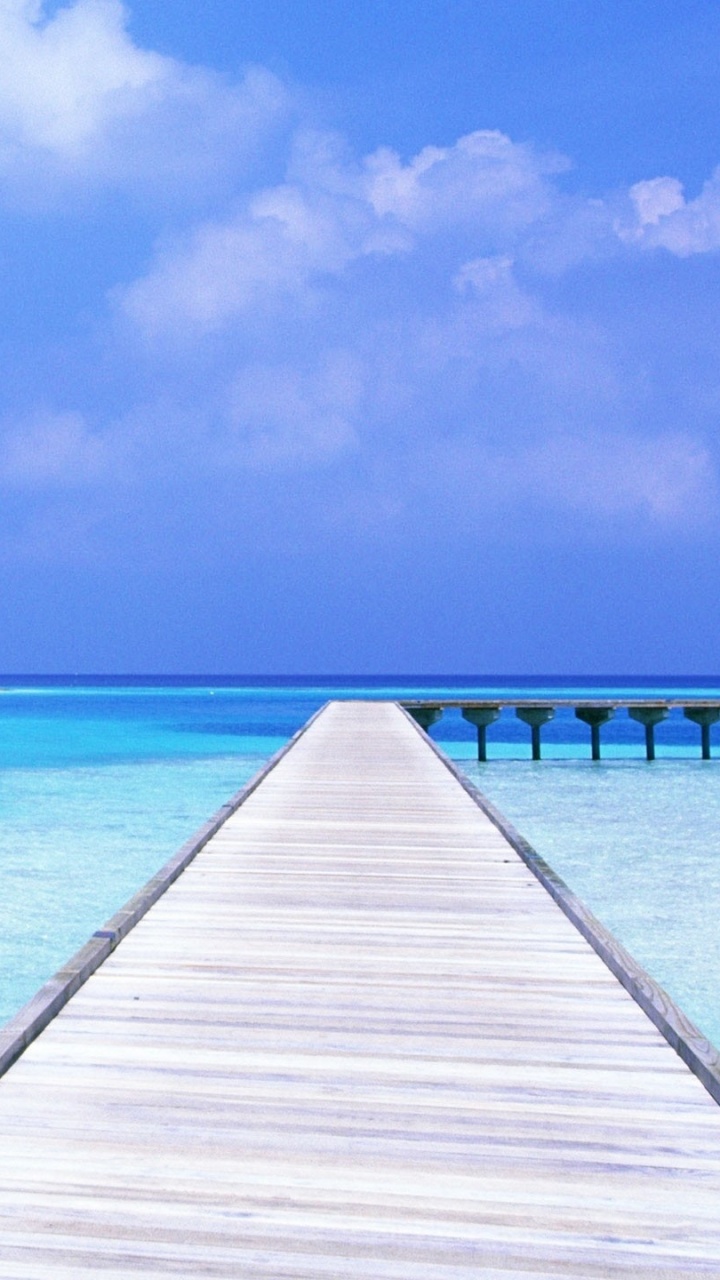 Brown Wooden Dock on Blue Sea Under Blue Sky During Daytime. Wallpaper in 720x1280 Resolution
