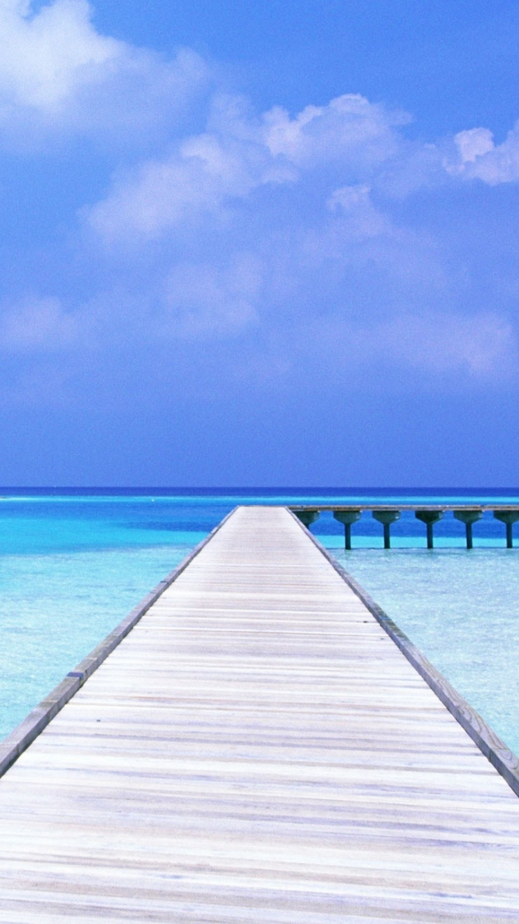 Brown Wooden Dock on Blue Sea Under Blue Sky During Daytime. Wallpaper in 750x1334 Resolution