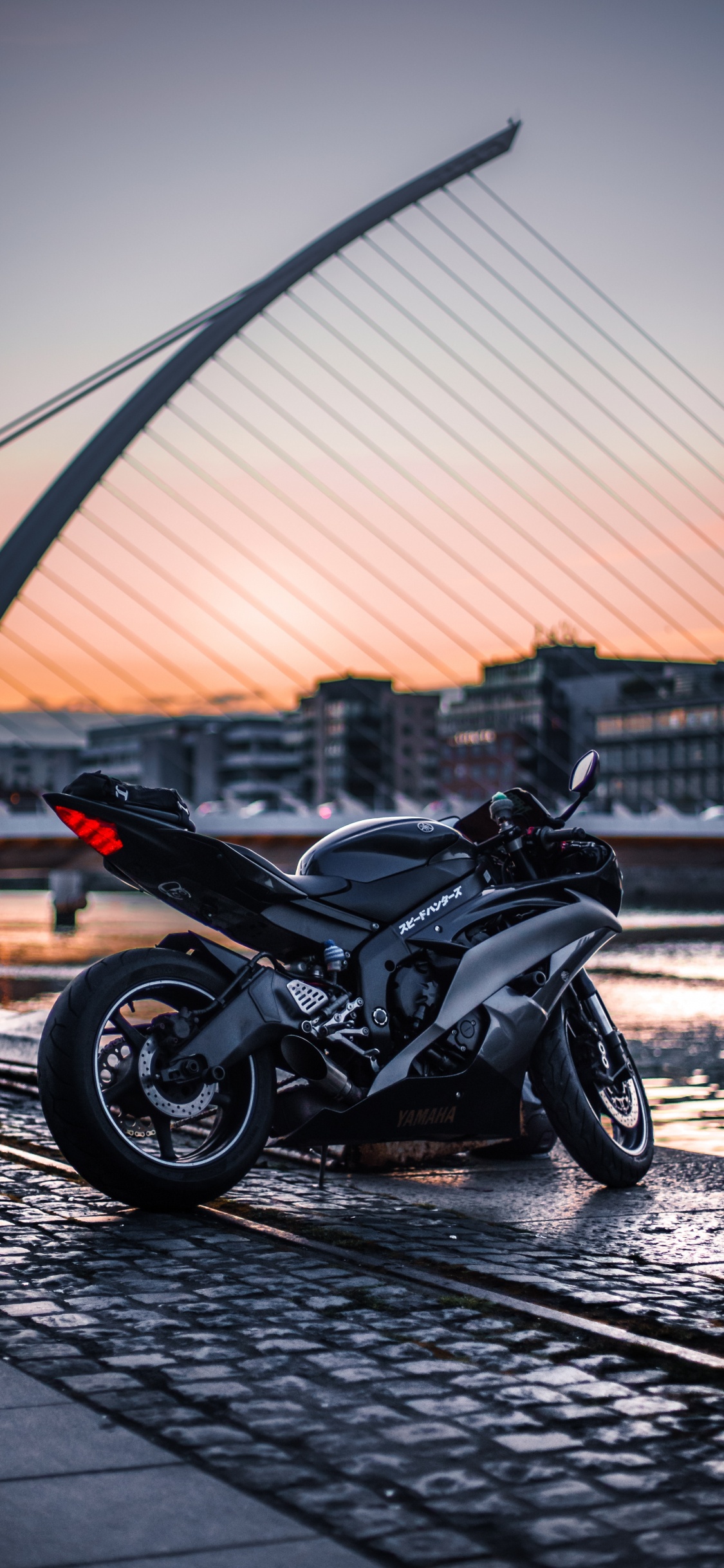 Black Sports Bike Parked on The Side of The Road. Wallpaper in 1125x2436 Resolution