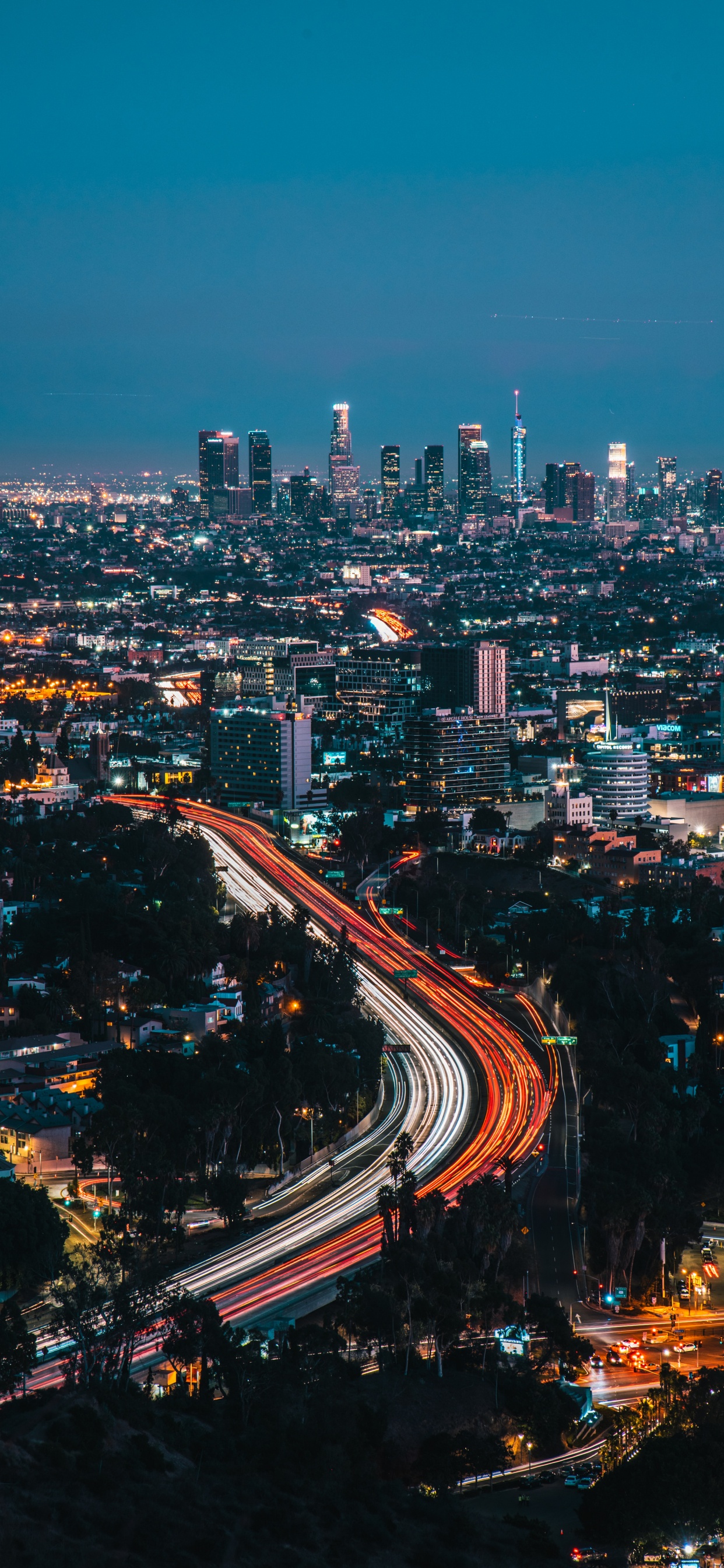 Zeitrafferfotografie Der Stadt Während Der Nachtzeit. Wallpaper in 1242x2688 Resolution