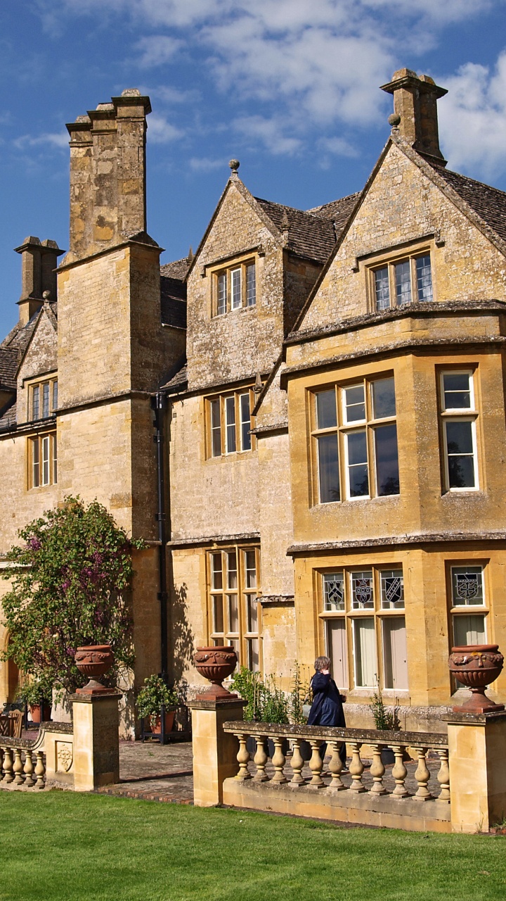 Braunes Betongebäude Mit Grünem Rasen. Wallpaper in 720x1280 Resolution