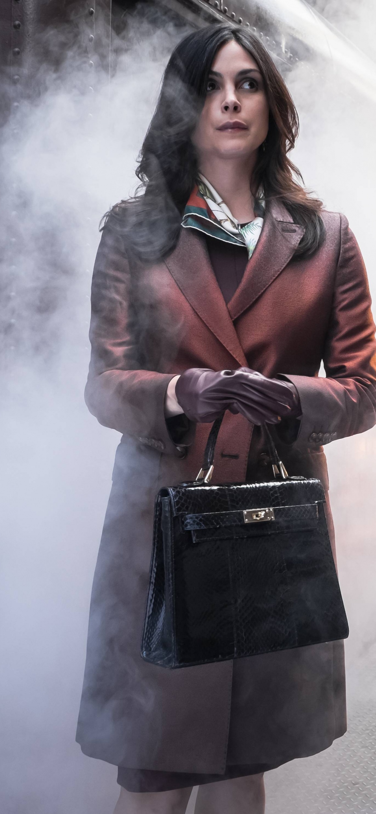 Woman in Brown Coat Standing on Gray Concrete Pavement. Wallpaper in 1242x2688 Resolution