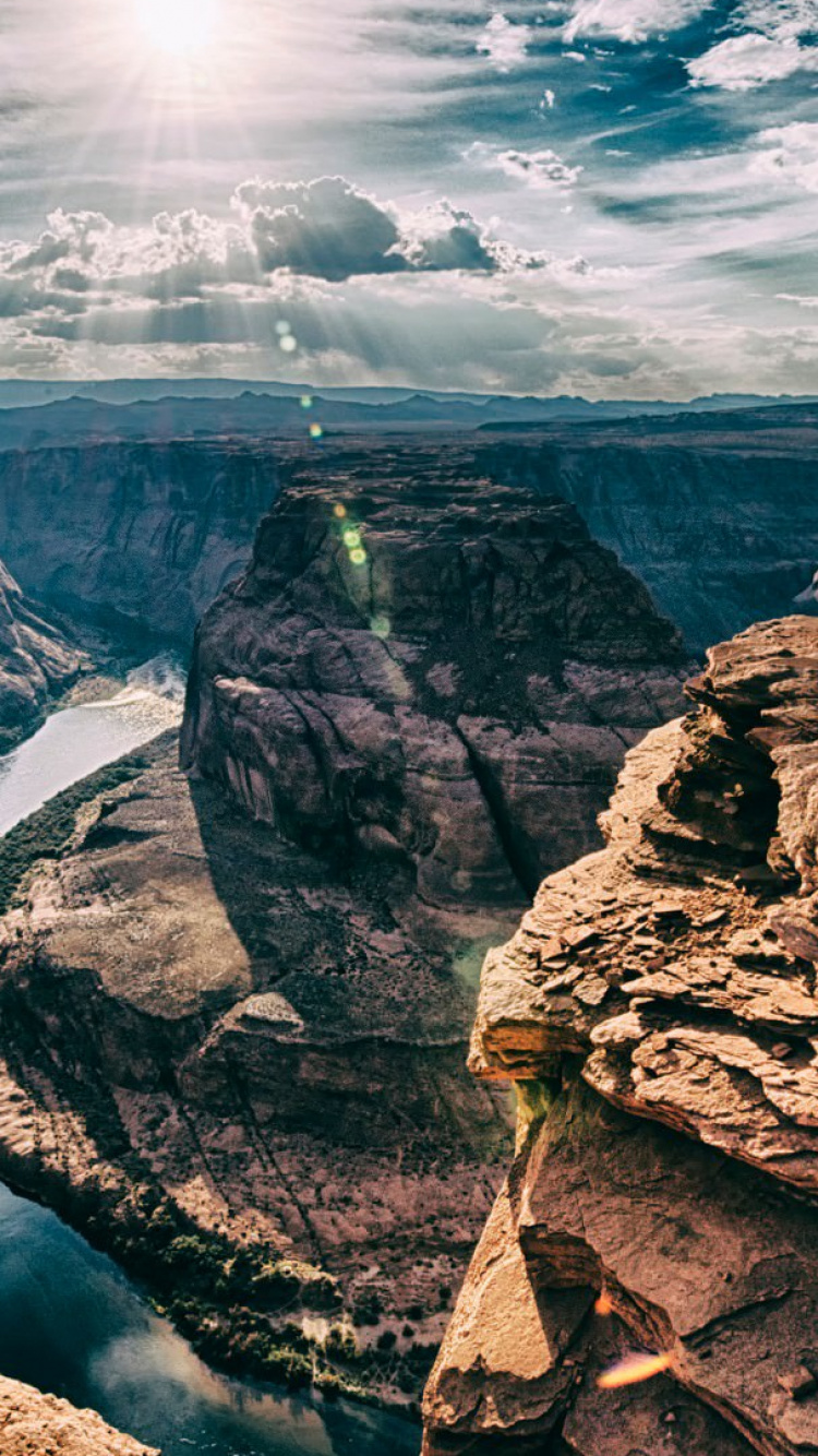 Brauner Felsiger Berg Unter Weißen Wolken Tagsüber. Wallpaper in 750x1334 Resolution