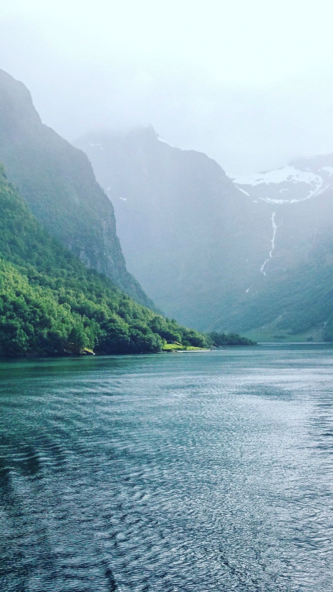 Tagsüber Grüne Berge Neben Dem Gewässer. Wallpaper in 1080x1920 Resolution