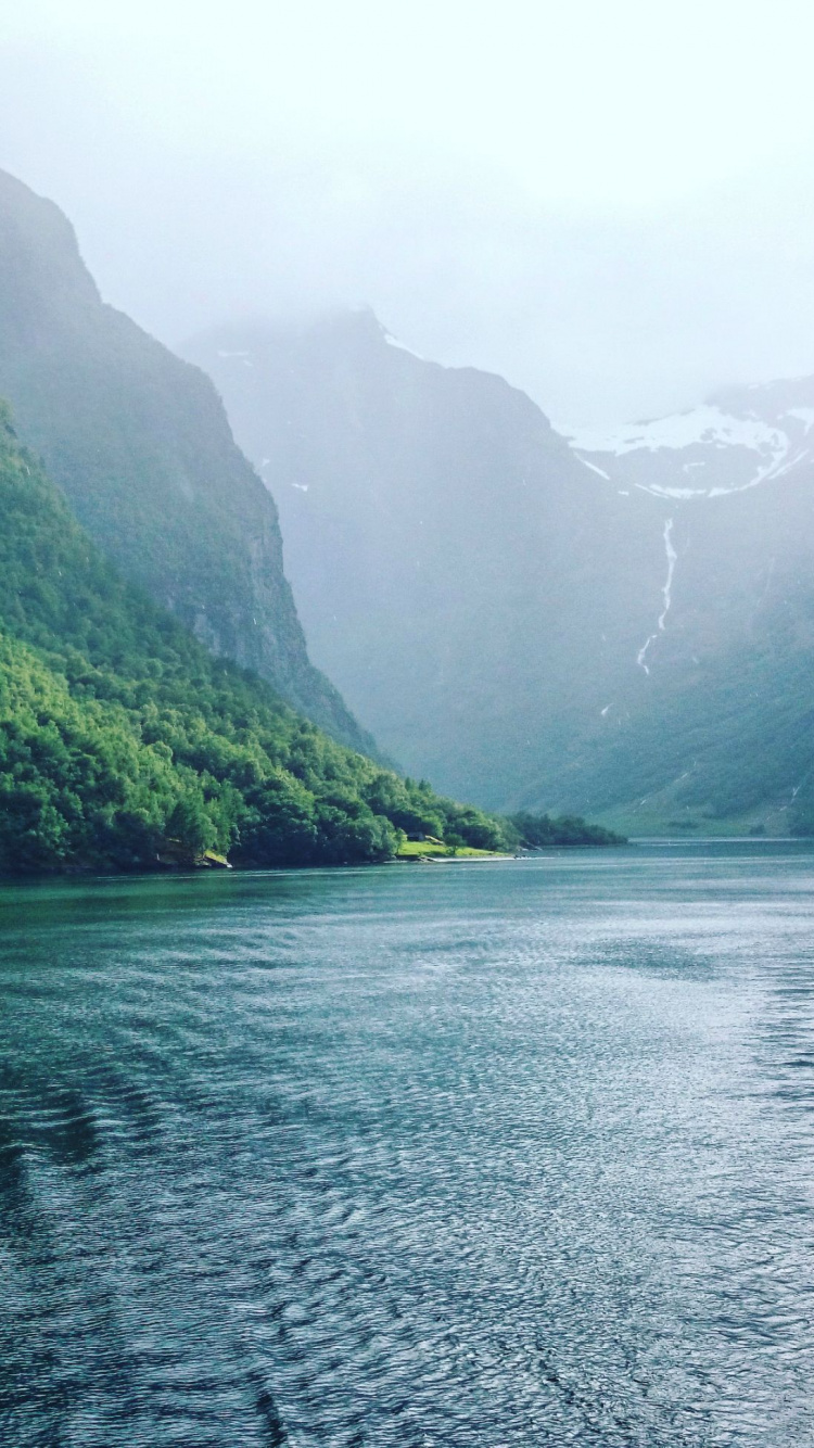 Montagnes Vertes à Côté D'un Plan D'eau Pendant la Journée. Wallpaper in 750x1334 Resolution