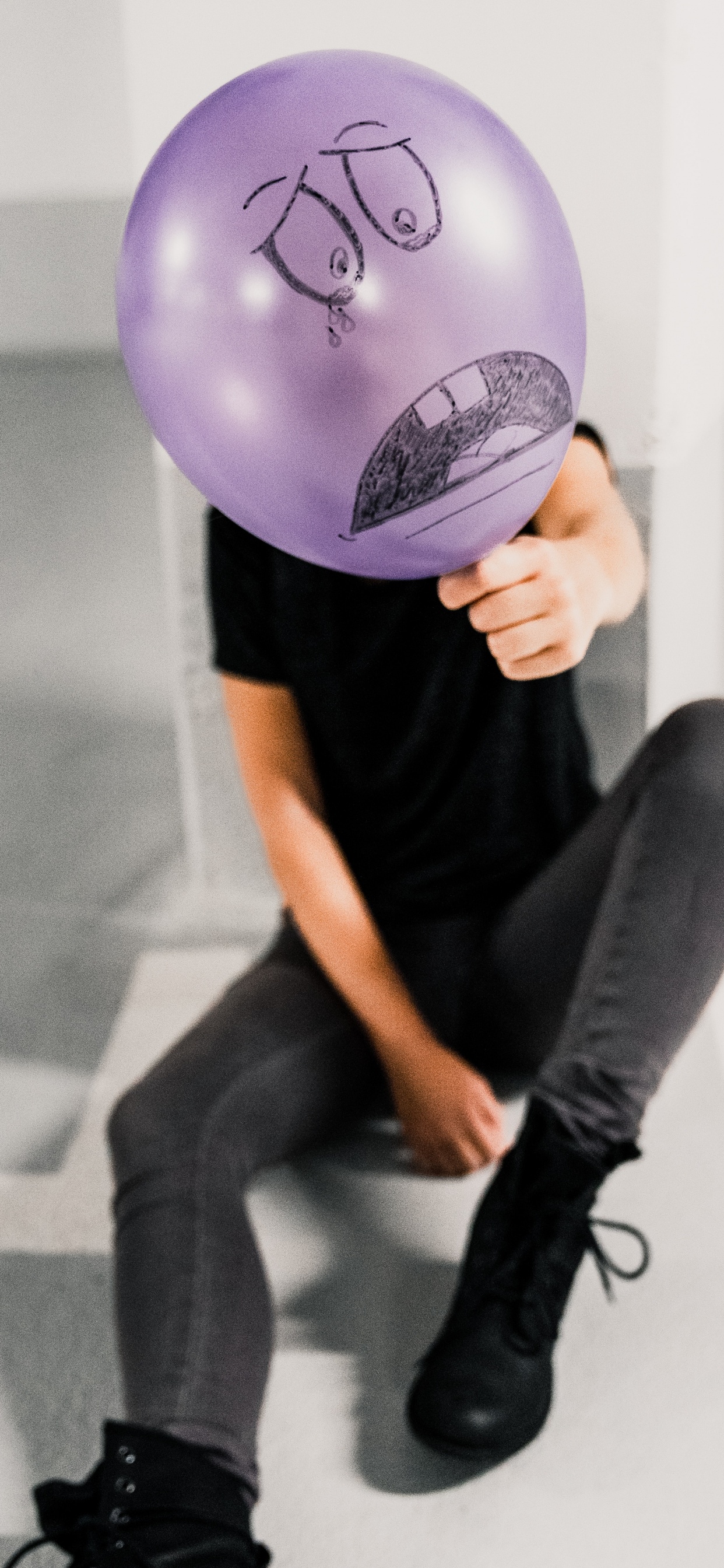 Persona Sosteniendo Globo Morado Cerca de la Pared Blanca. Wallpaper in 1242x2688 Resolution