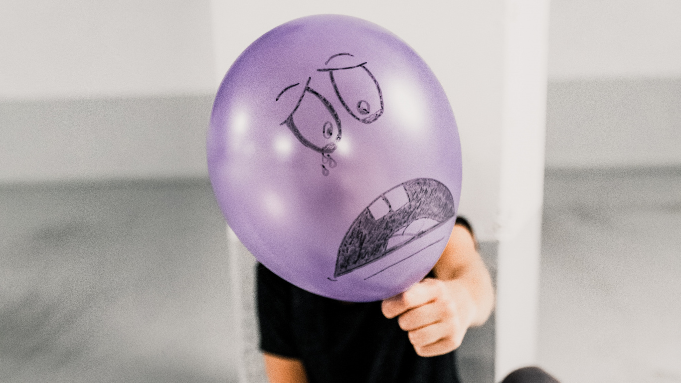 Person Holding Purple Balloon Near White Wall. Wallpaper in 1366x768 Resolution