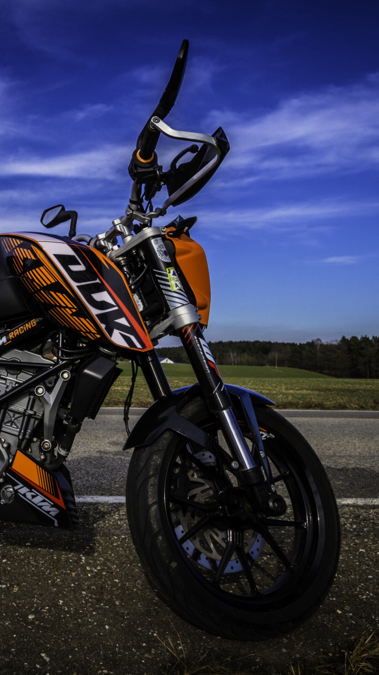 Moto Orange et Noire Sur Route Goudronnée Noire. Wallpaper in 750x1334 Resolution