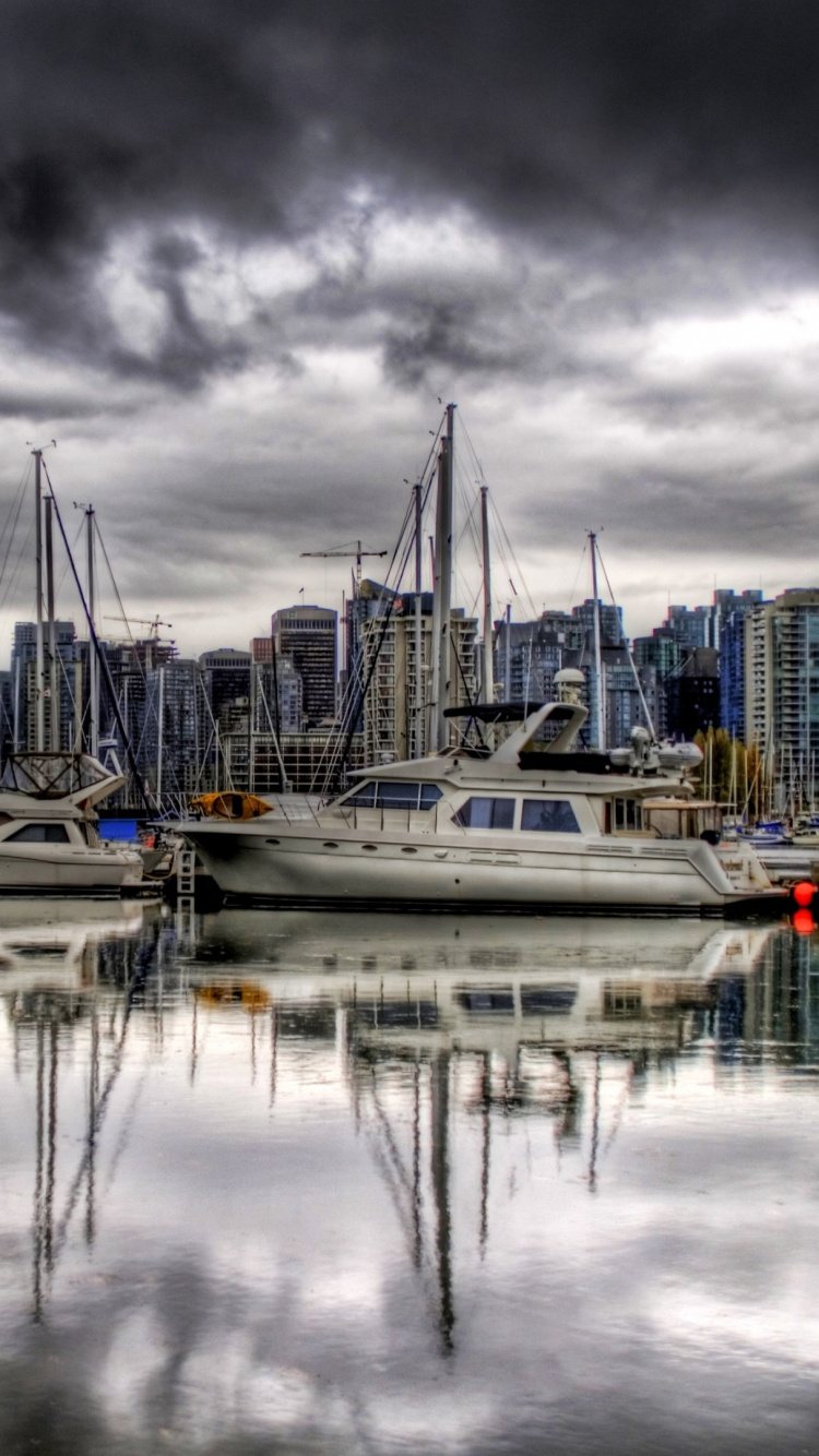 Bateau Blanc et Bleu Sur le Quai Sous Les Nuages Gris. Wallpaper in 750x1334 Resolution