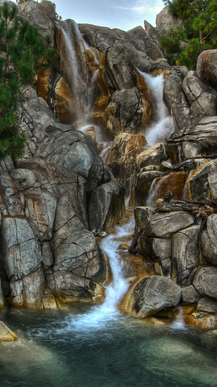 Grauer Felsiger Fluss Mit Grauem Felsigem Berg in Der Ferne. Wallpaper in 750x1334 Resolution
