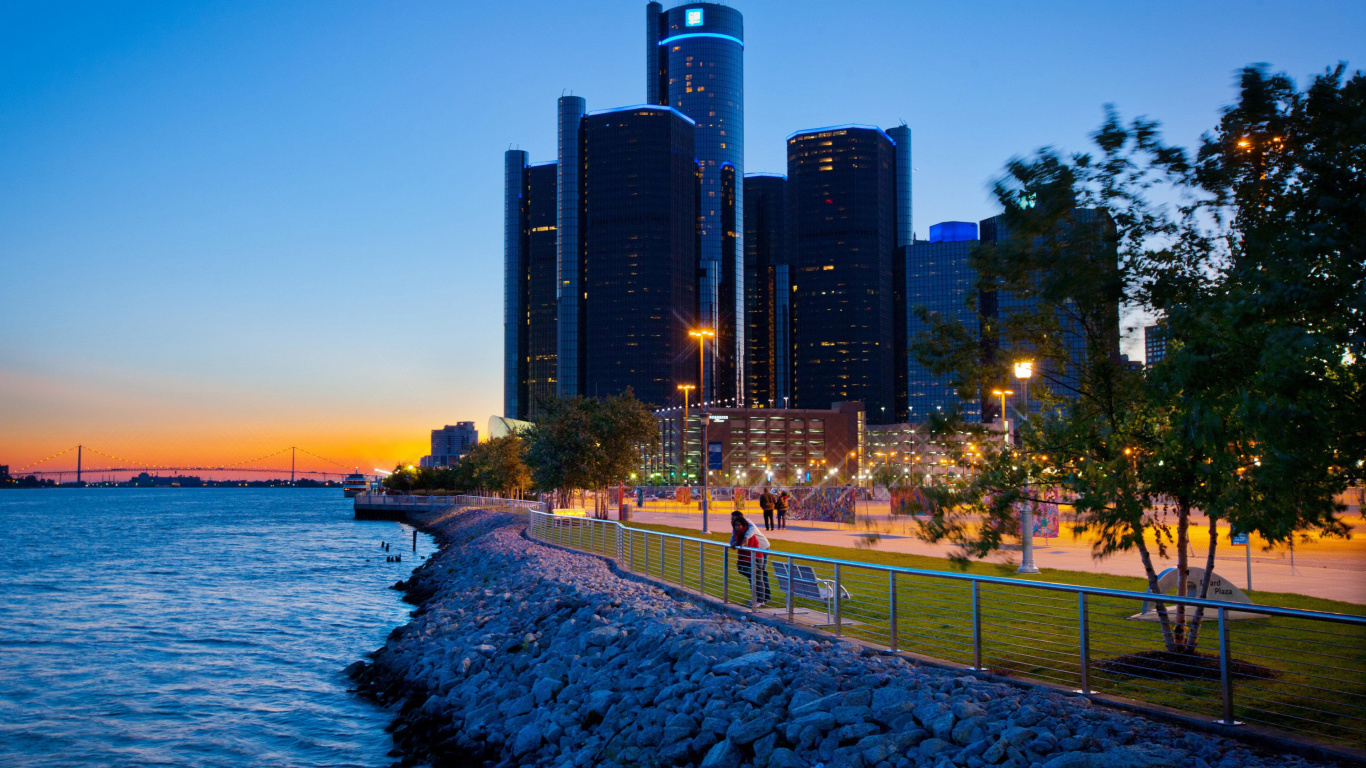 People Walking on Sidewalk Near Body of Water During Sunset. Wallpaper in 1366x768 Resolution