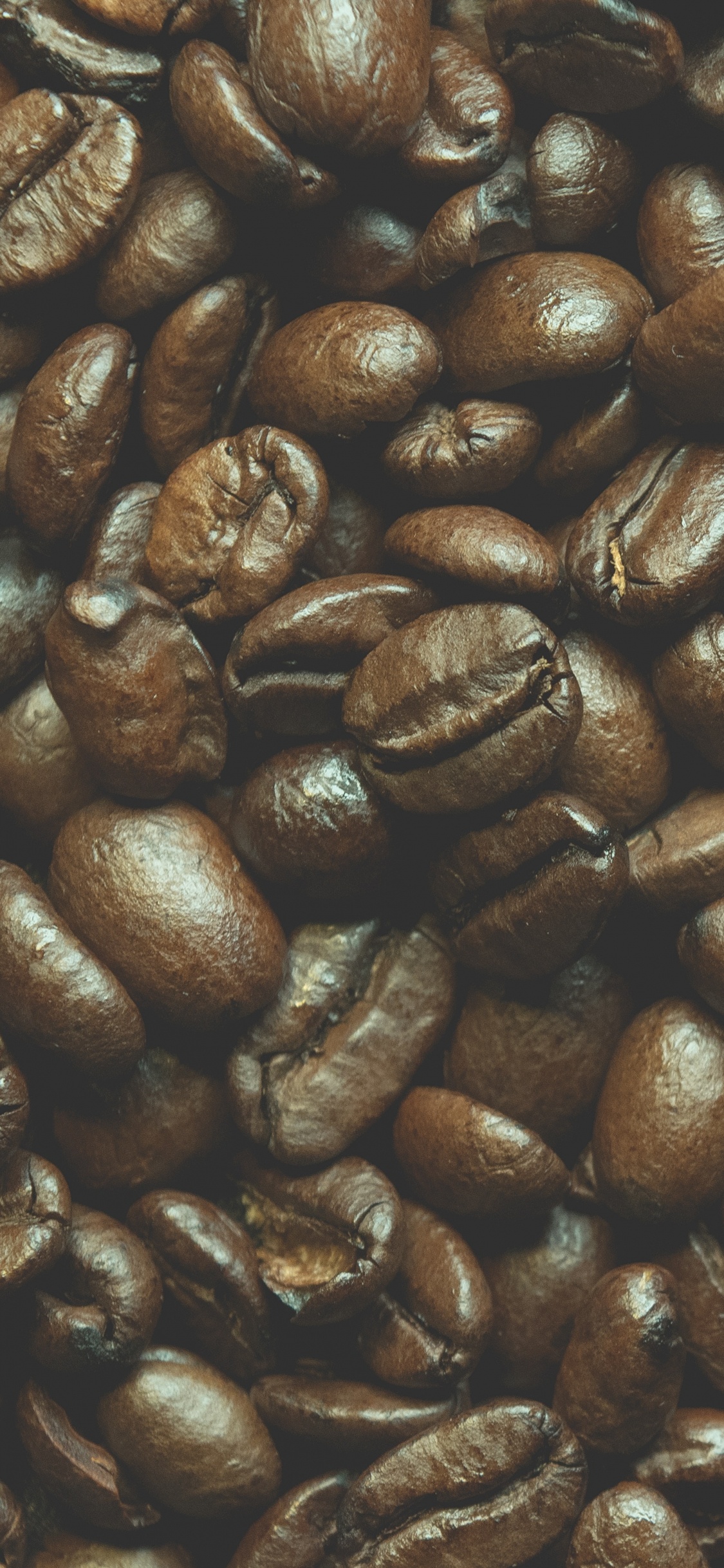 Brown Coffee Beans on Black Surface. Wallpaper in 1125x2436 Resolution