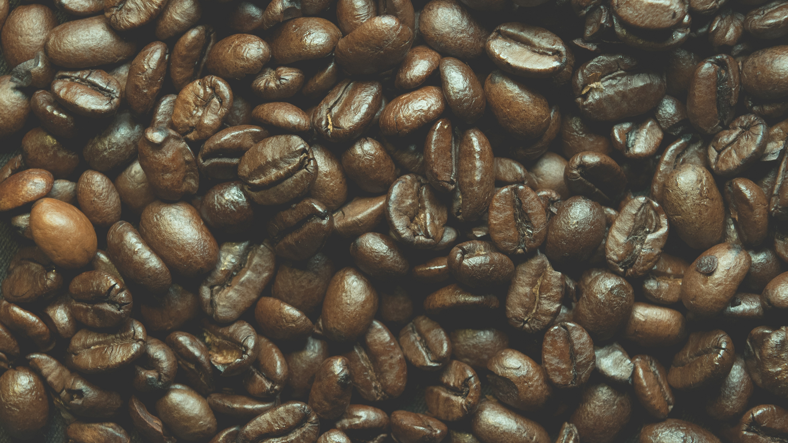 Braune Kaffeebohnen Auf Schwarzer Oberfläche. Wallpaper in 2560x1440 Resolution