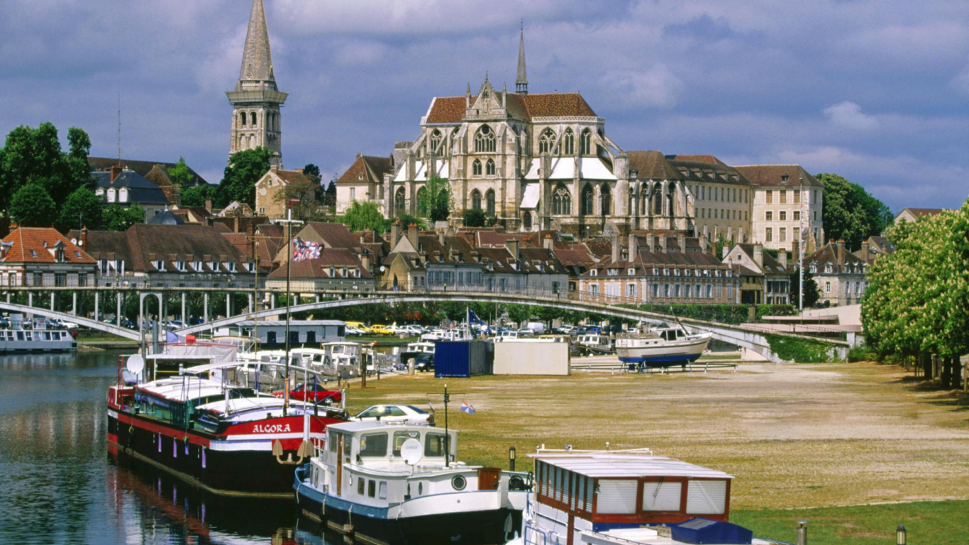 Bateau Blanc et Bleu Sur le Quai Près D'un Bâtiment en Béton Brun Pendant la Journée. Wallpaper in 1366x768 Resolution