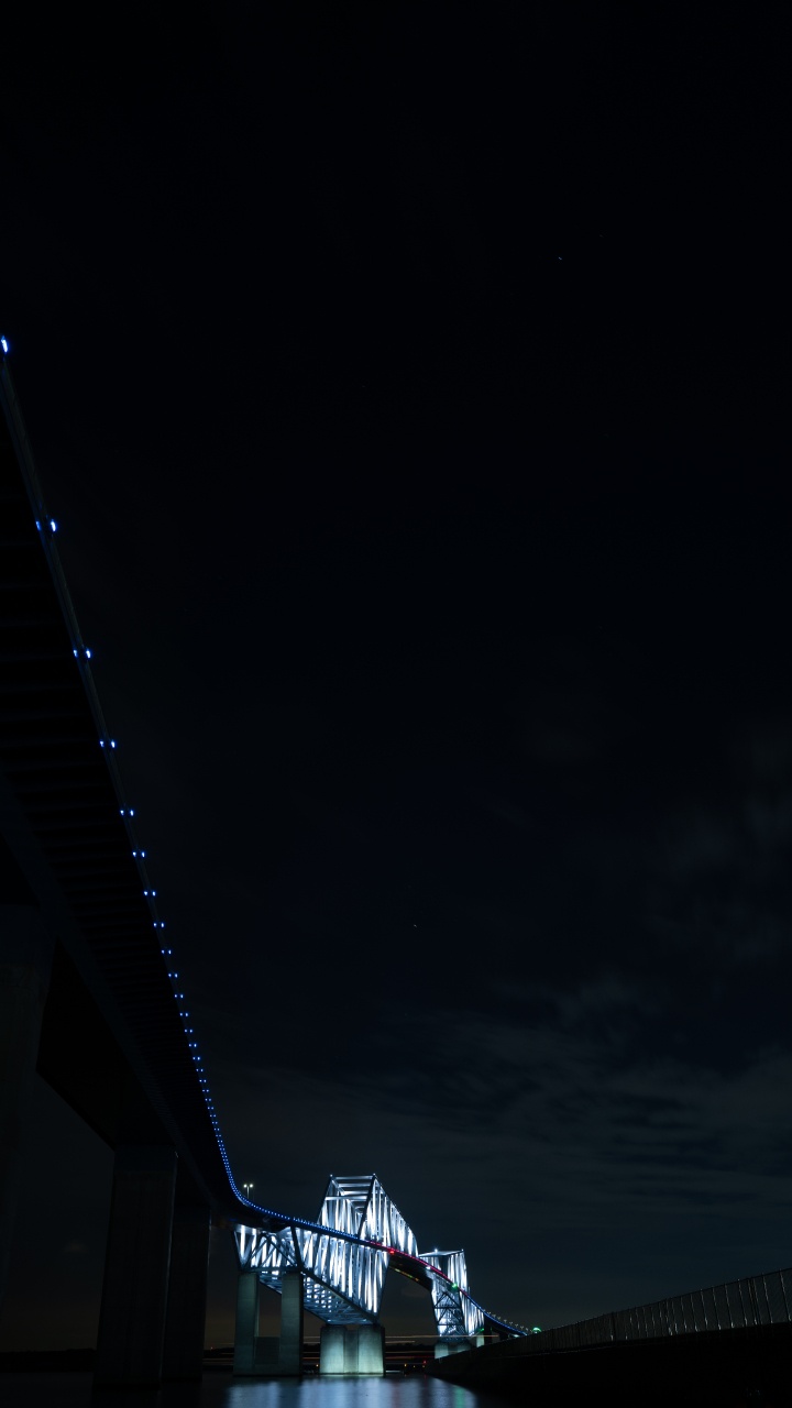 Weiße Und Schwarze Brücke Unter Dunklem Himmel. Wallpaper in 720x1280 Resolution