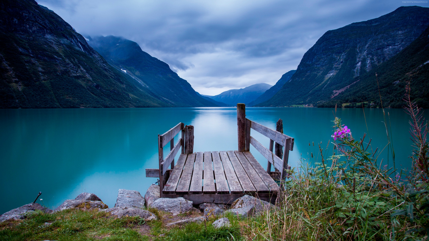 Brown Wooden Bench on Green Grass Field Near Lake and Mountains During Daytime. Wallpaper in 1366x768 Resolution