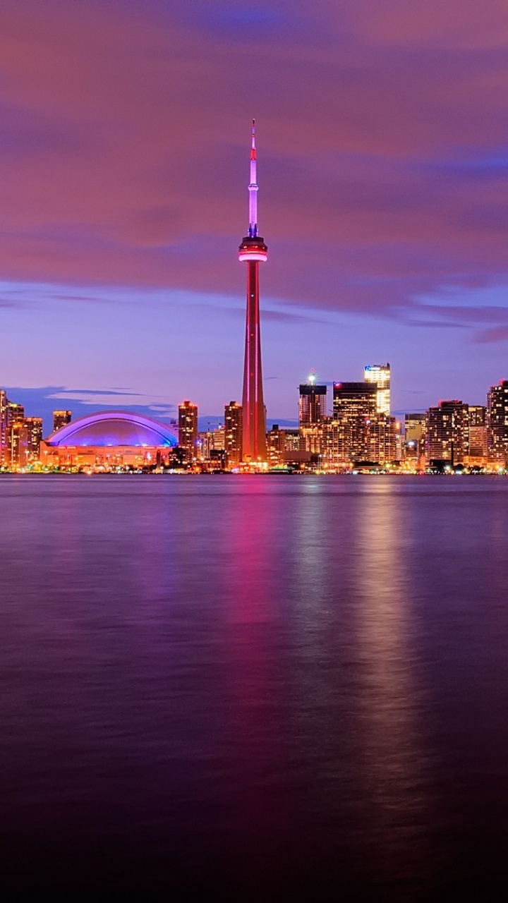 City Skyline Across Body of Water During Night Time. Wallpaper in 720x1280 Resolution