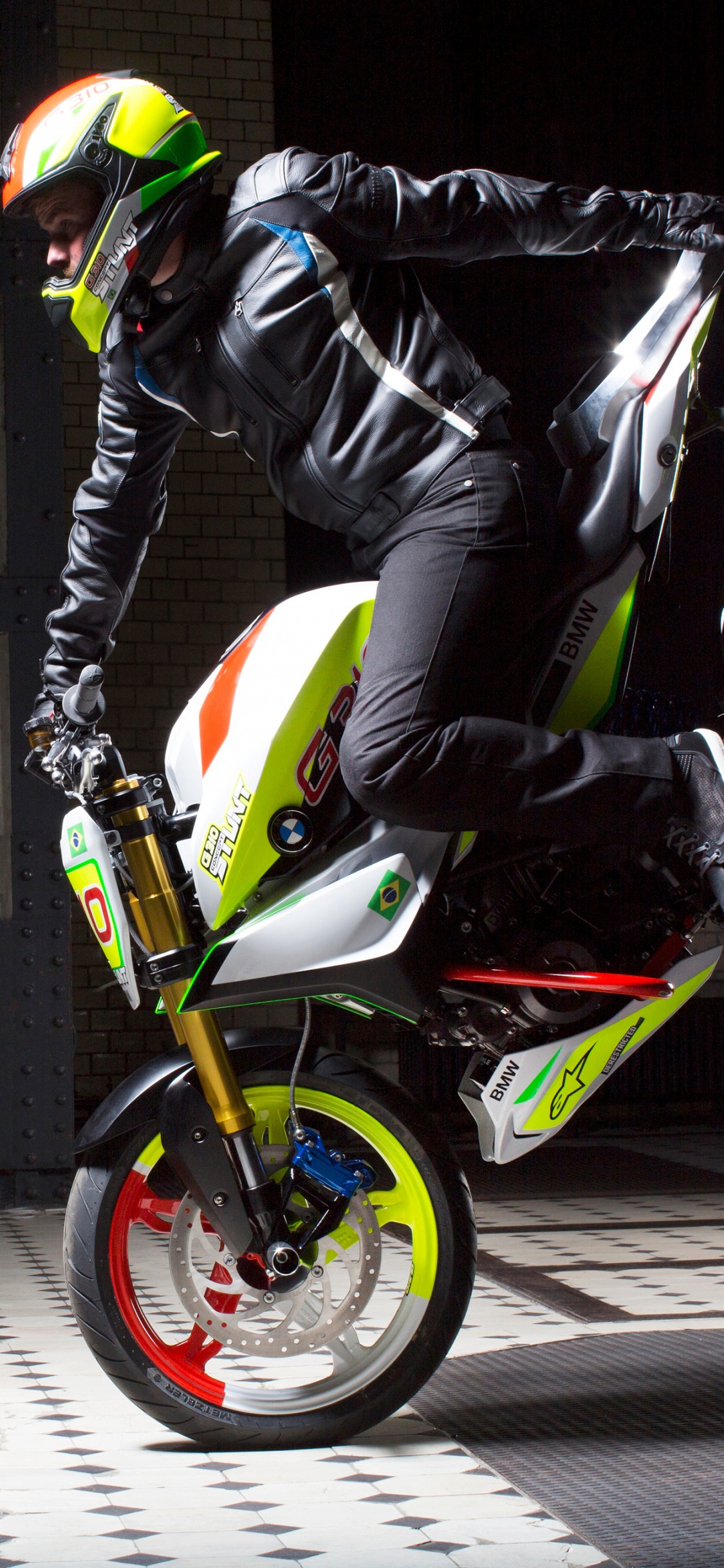 Man in Black Leather Jacket Riding Green Motorcycle. Wallpaper in 1125x2436 Resolution