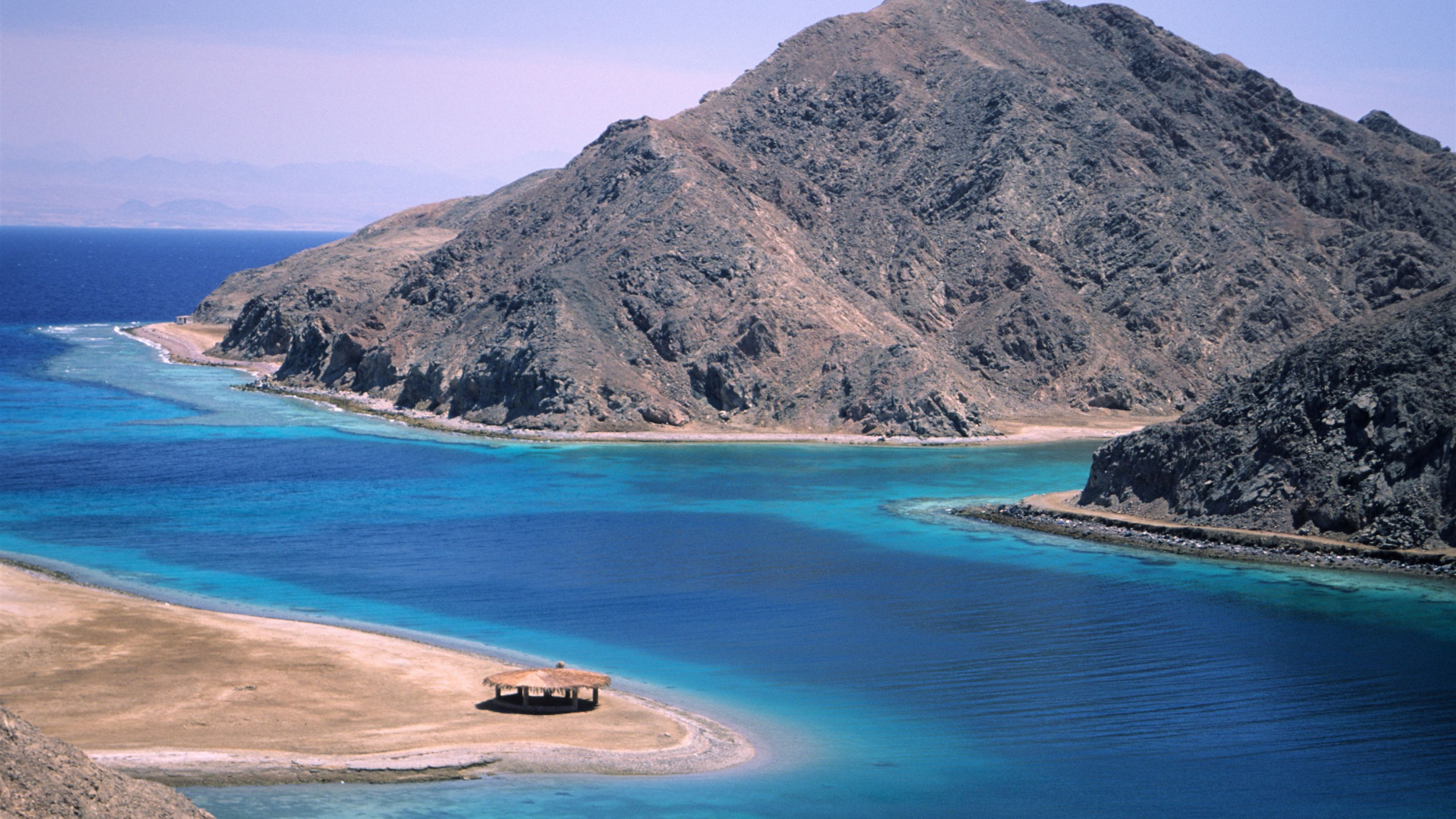 Brown and Green Mountain Beside Body of Water During Daytime. Wallpaper in 2560x1440 Resolution