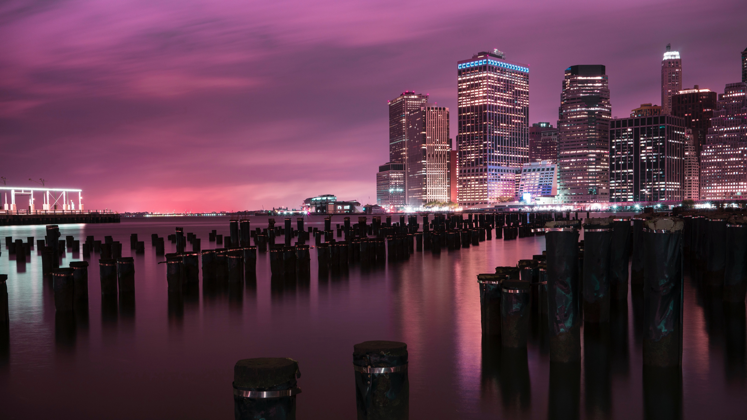 Skyline Der Stadt Über Gewässer Während Der Nacht. Wallpaper in 2560x1440 Resolution