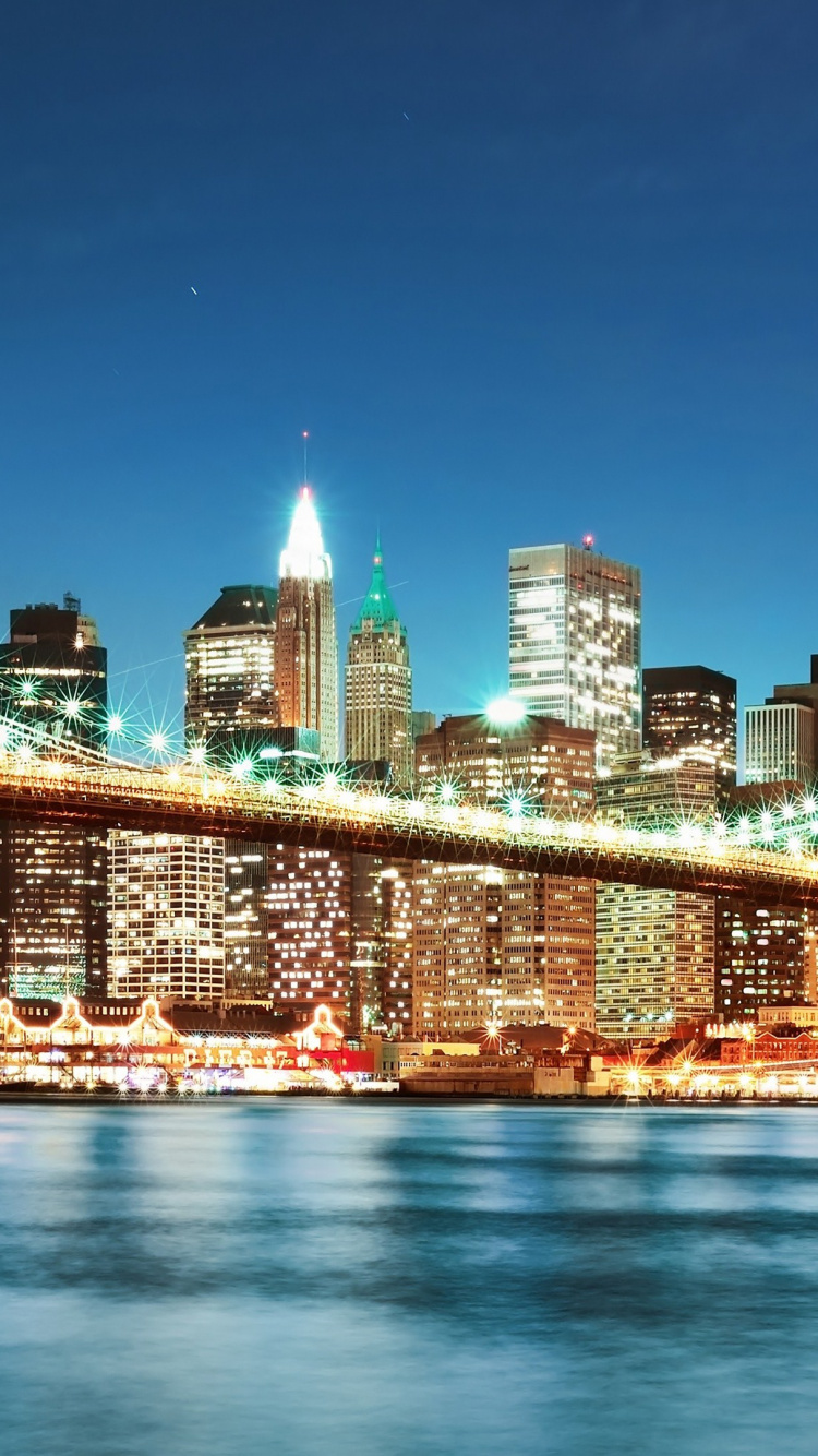 Lighted Bridge Over Water During Night Time. Wallpaper in 750x1334 Resolution