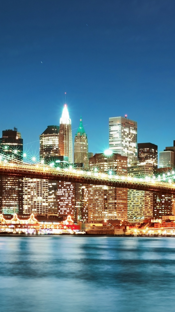 Beleuchtete Brücke Über Wasser Während Der Nacht Night. Wallpaper in 720x1280 Resolution