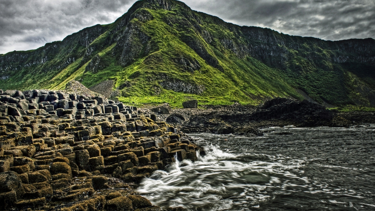 Green Mountain Beside Body of Water. Wallpaper in 1280x720 Resolution