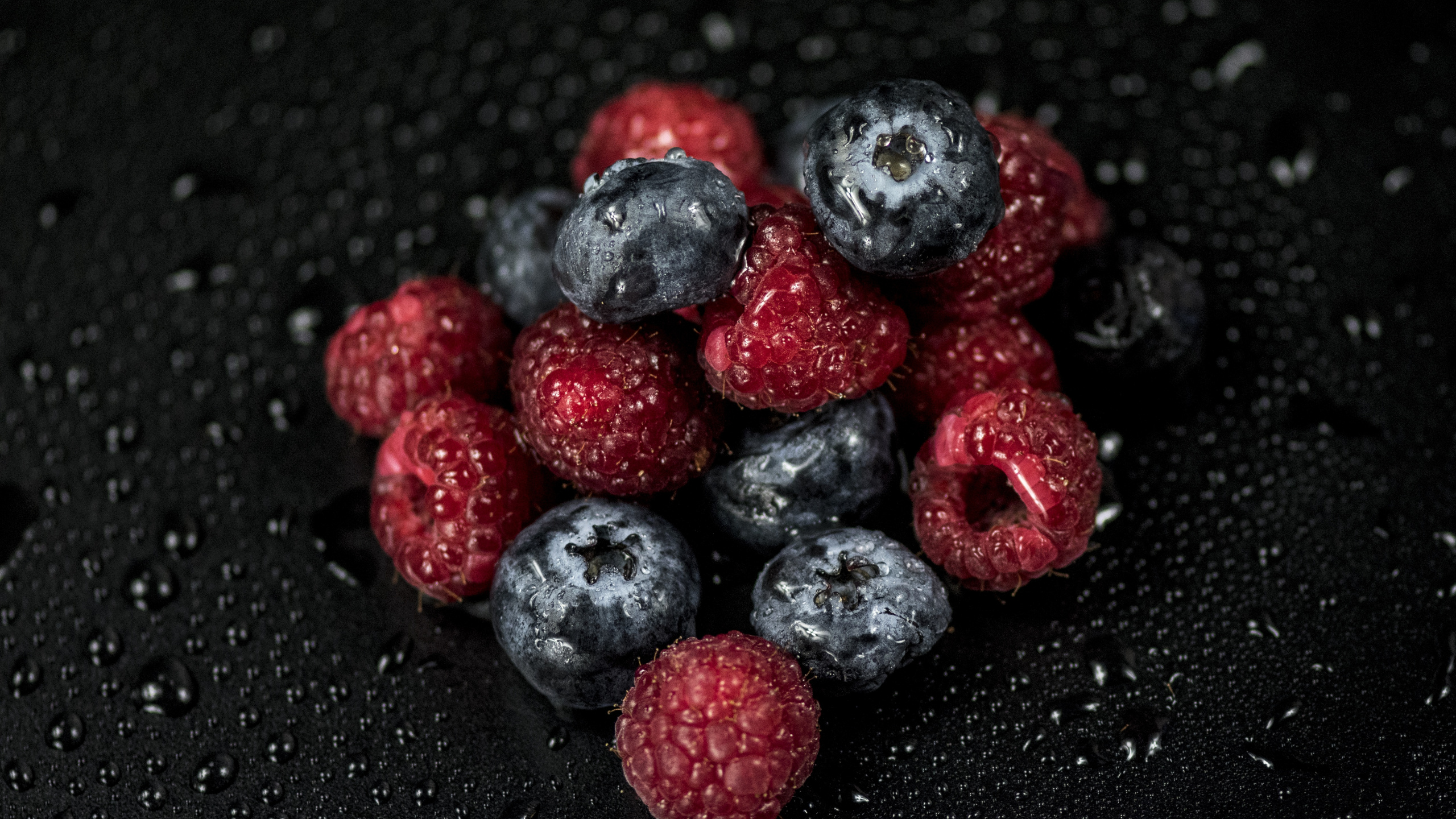 Red and Black Berries on Black Surface. Wallpaper in 2560x1440 Resolution